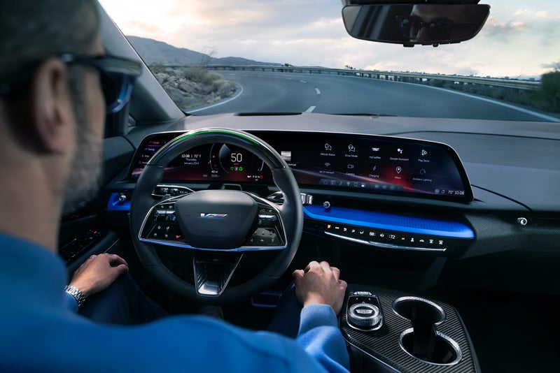 Front View of the 2026 OPTIQ-V Driving Through the Dusk Utilizing its Headlights | Burns Cadillac in Rock Hill SC